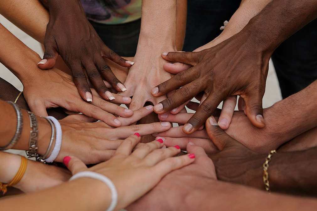 Many hands together: group of diverse people joining hands