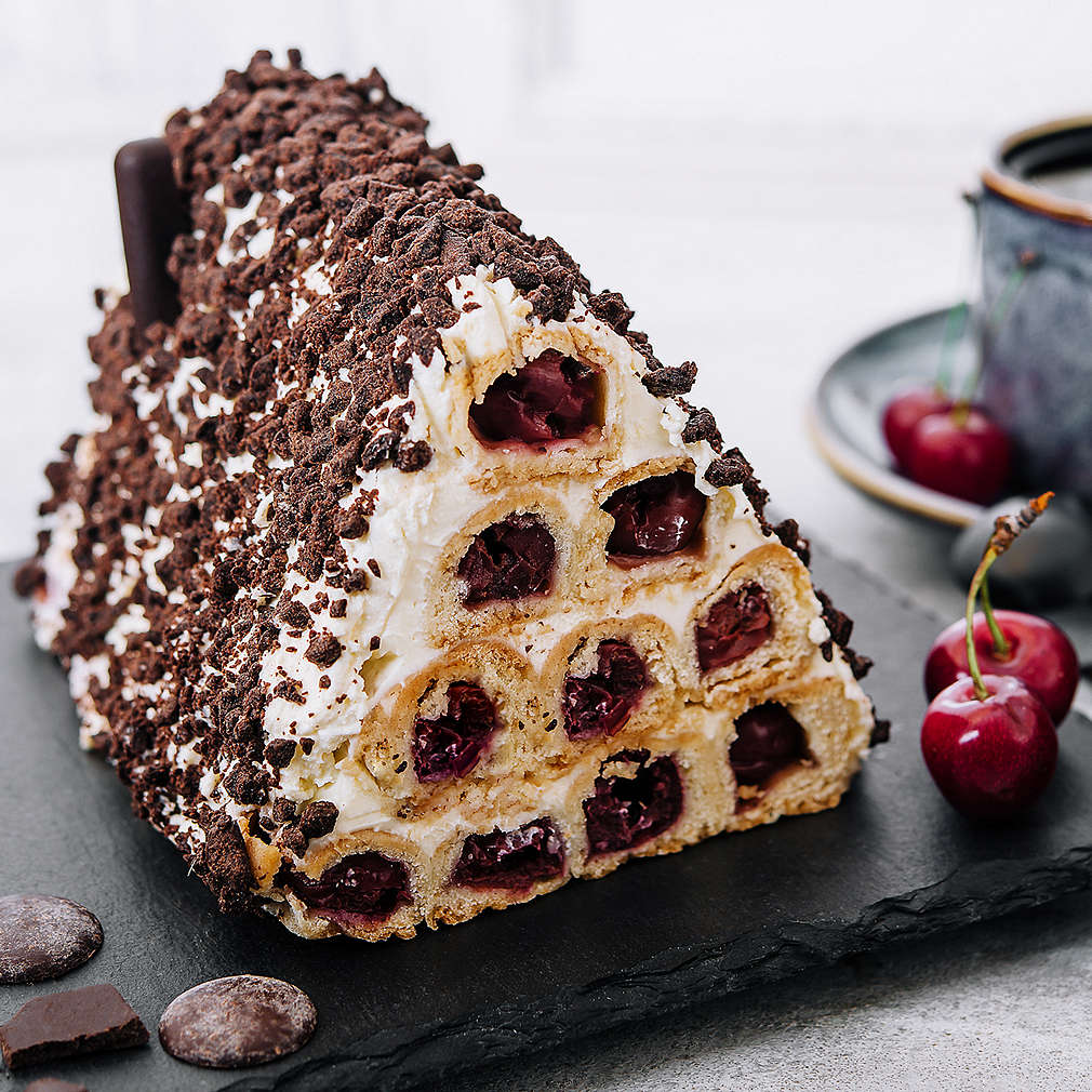 Triangle cherry cake with cream and chocolate sprinkles