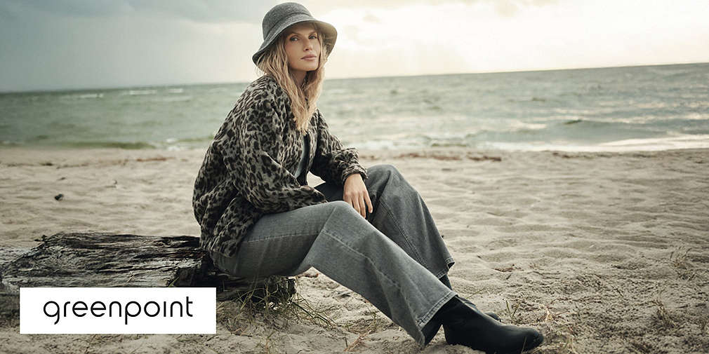 Kobieta siedzi na skale na tle morza