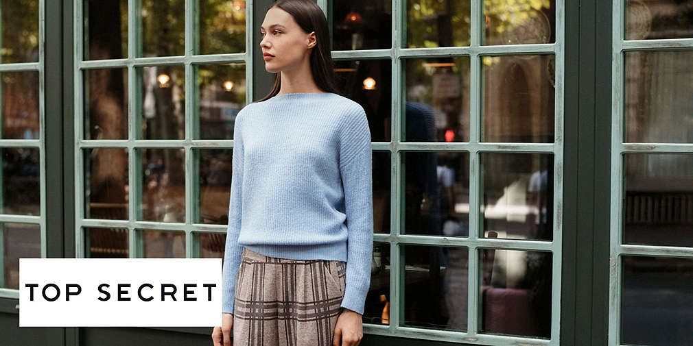 Kobieta stoi przed witryną sklepu