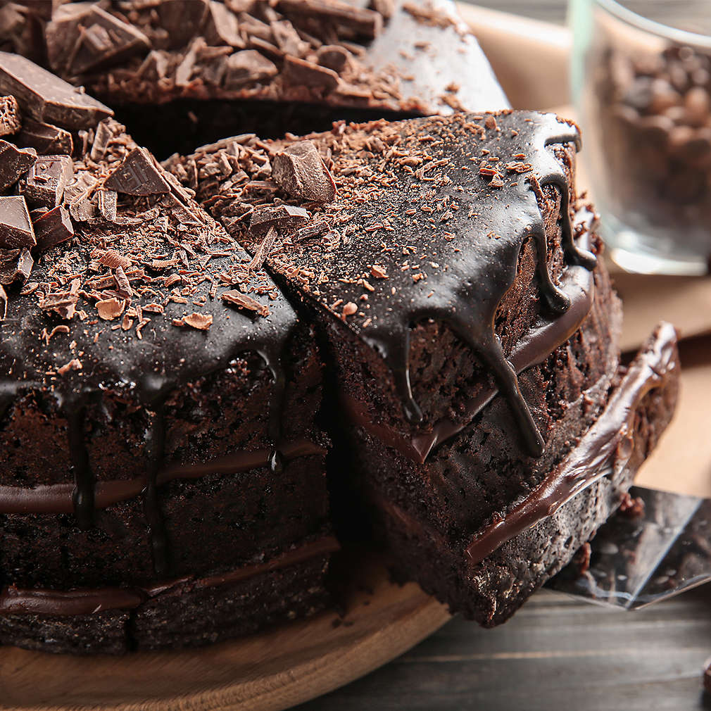 Plate with delicious chocolate cake on wooden table, closeup