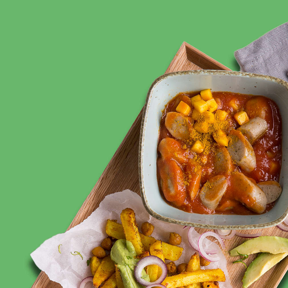 Vegane Currywurst auf grünem Untergrund