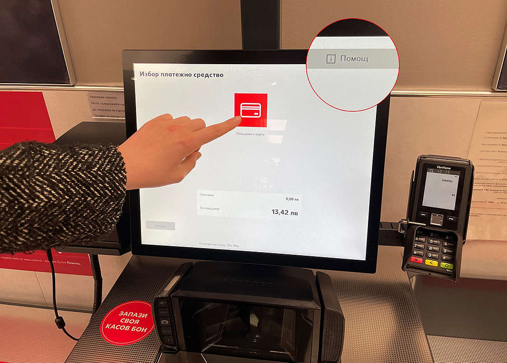 Изображение на монитора на касата на самообслужване и бутона, с който може да се потърси помощ от колега в хипермаркета