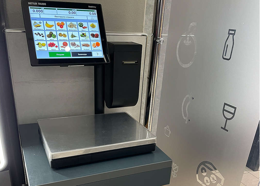 Изображение на везна за теглене на плодове и зеленчуци, която сме поставили в зоната на касите на самообслужване