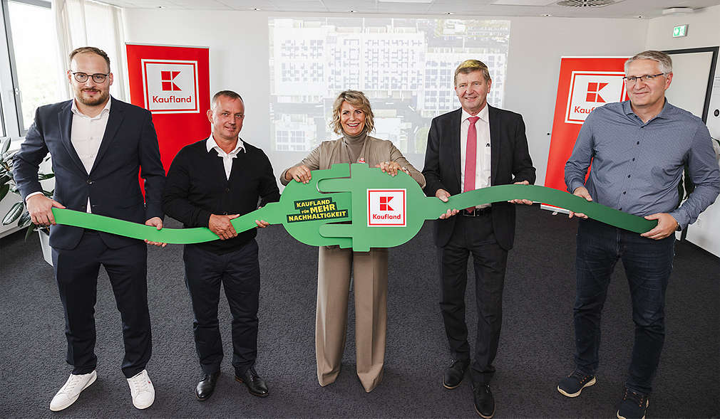 Abbildung: Kaufland-Mitarbeiter, die einen grünen Stecker aus Pappe in der Hand halten. Schriftzug: Kaufland für mehr Nachhaltigkeit; Logo: Kaufland