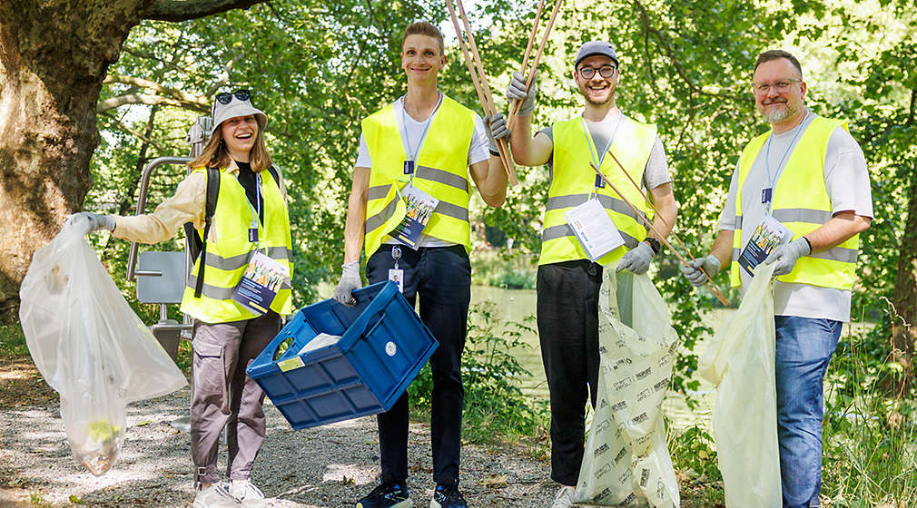 Personen lächeln bei der Cleanup-Aktion in die Kamera