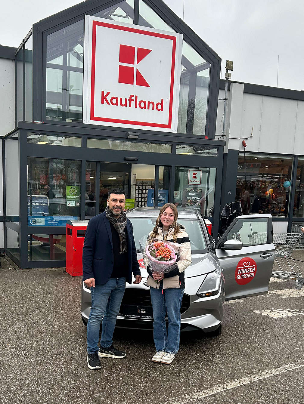 Gewinnübergabe vor einer Kaufland-Filiale