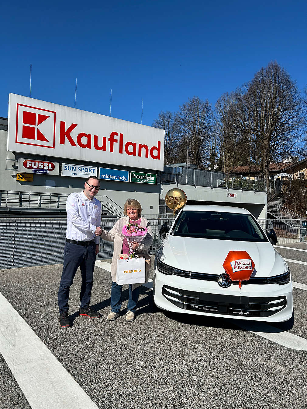 Gewinnübergabe vor einer Kaufland-Filiale