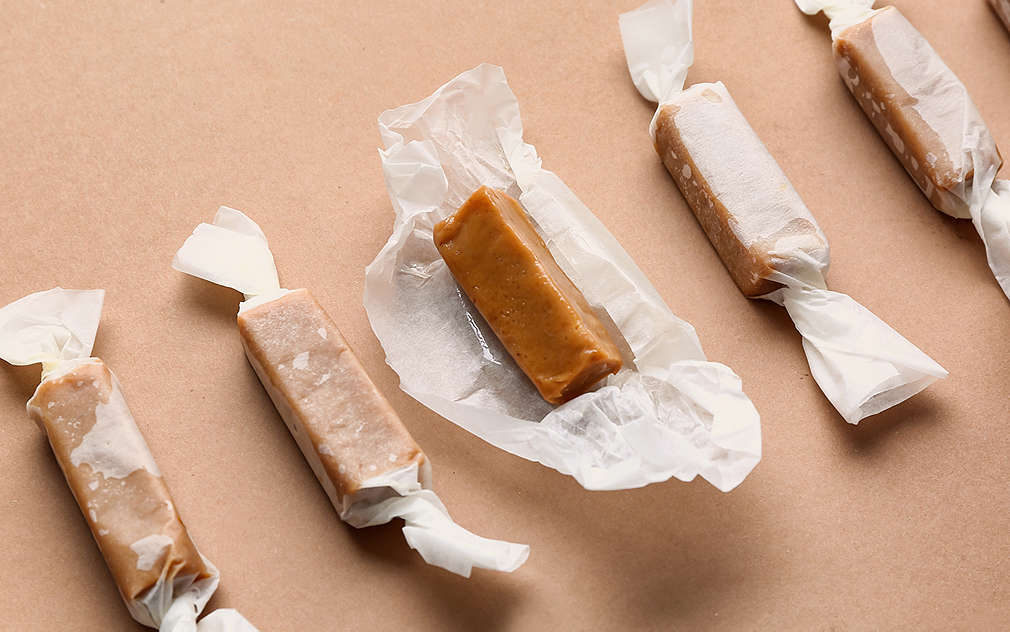 Tasty salty candies on color background