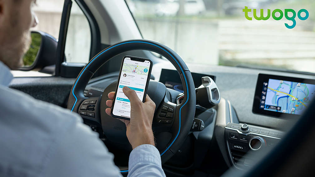Mann im Auto nutzt die App twogo; Logo: twogo