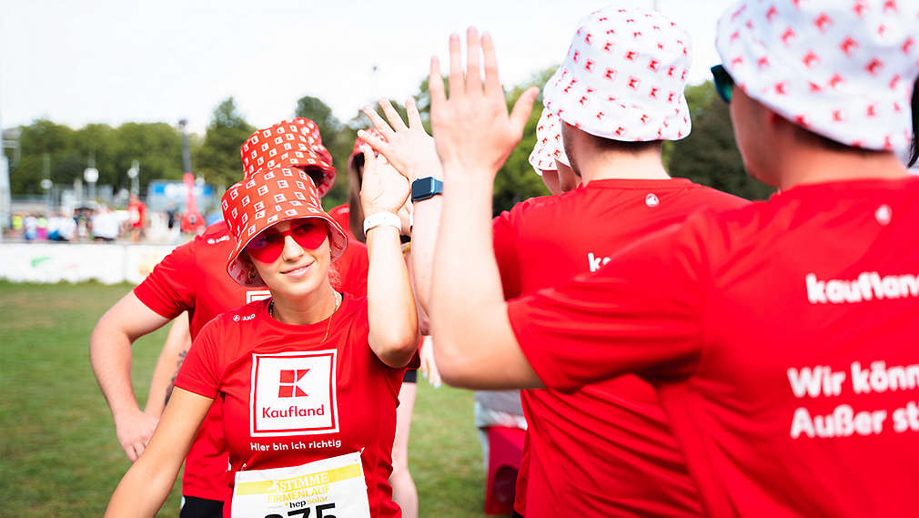 Kaufland-Mitarbeiter in Kaufland-Trikots bei einem Lauf-Event