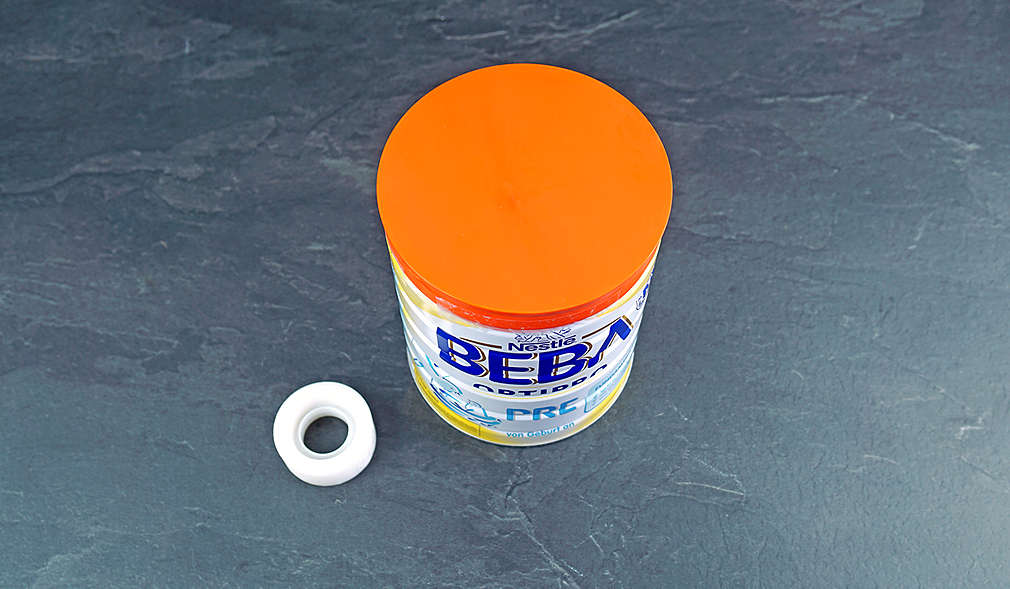 Abbildung: Klebebandrolle und Folgemilch-Dose