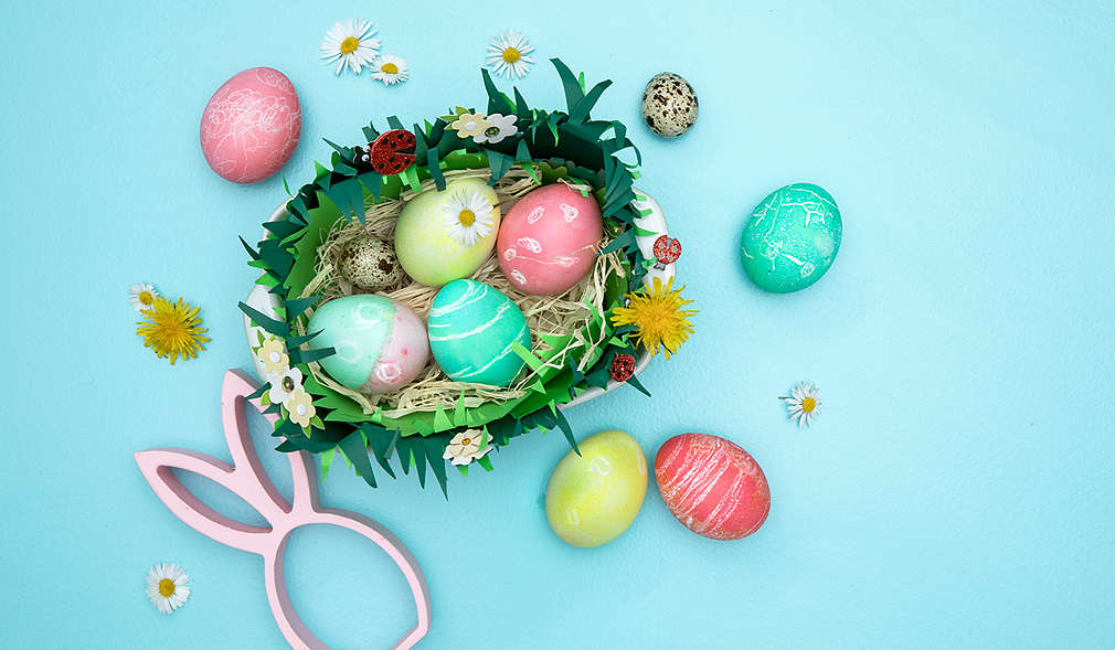 Ein Osterei das mit einem weißen Wachsmalstift und Lebensmittelfarbe gefärbt wurde