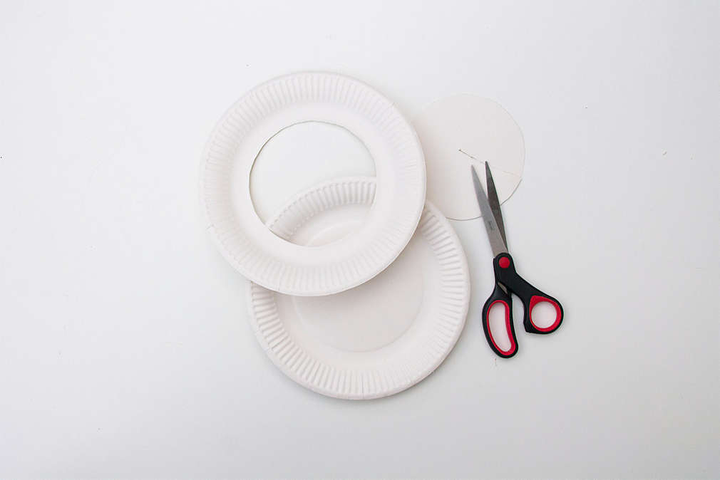 Bastelanleitung Frisbee-Ringewerfen: zwei ausgeschnittene Pappteller und Schere