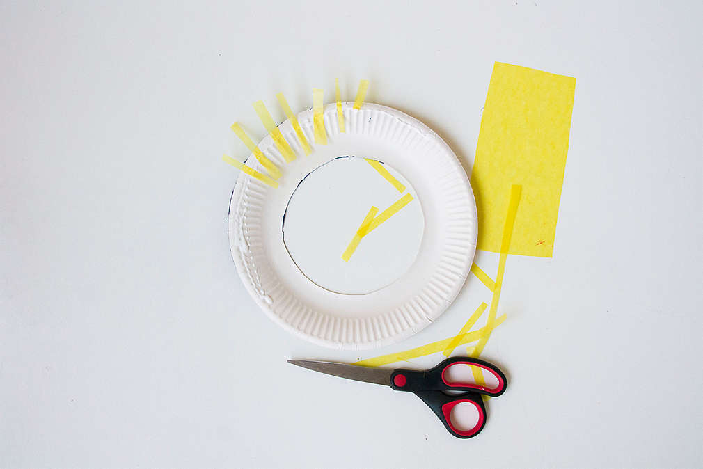 Bastelanleitung Frisbee-Ringewerfen: ausgeschnittener Pappteller, Schere, Pergament- und Tonpapier