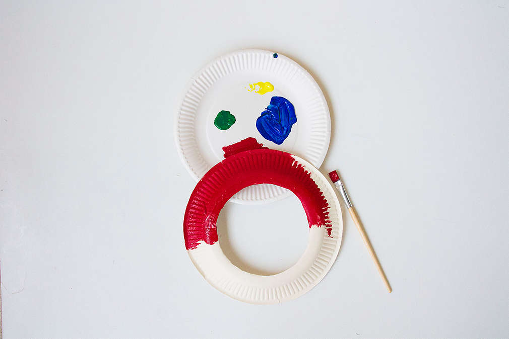 Bastelanleitung Frisbee-Ringewerfen: zwei ausgeschnittene Pappteller bemalen