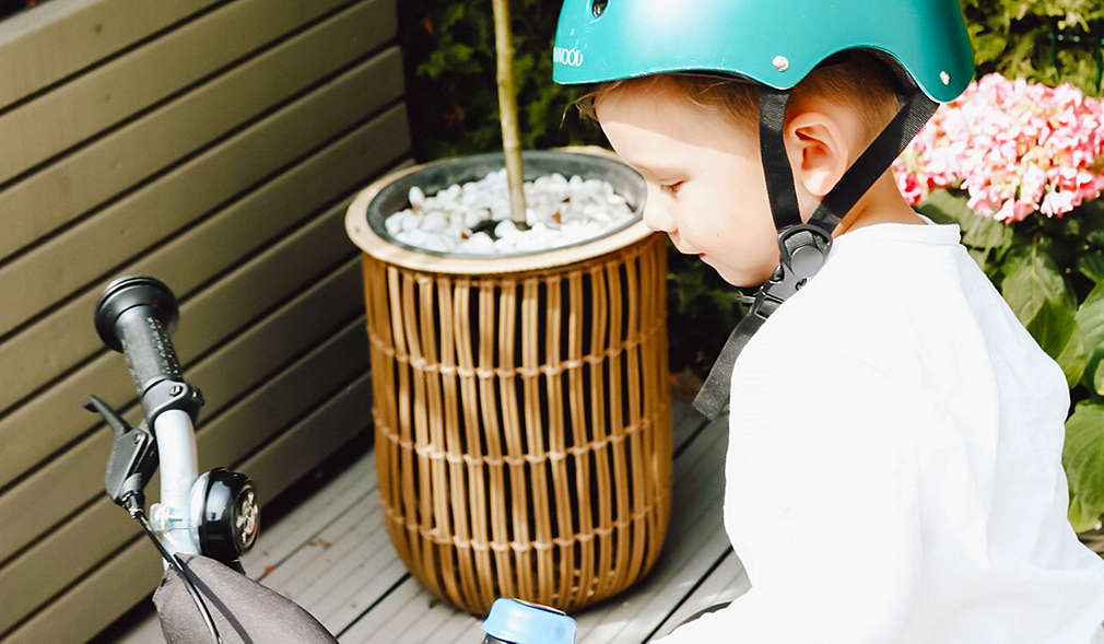 Kind mit einem Helm inspiziert ein Fahrrad
