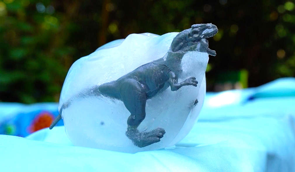 Spielzeugdinosaurier in einem Eisblock eingefroren