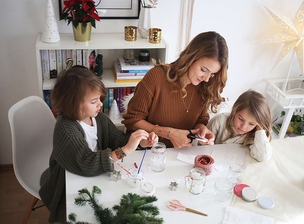 Mutter bastelt Windlichter mit ihren Kindern
