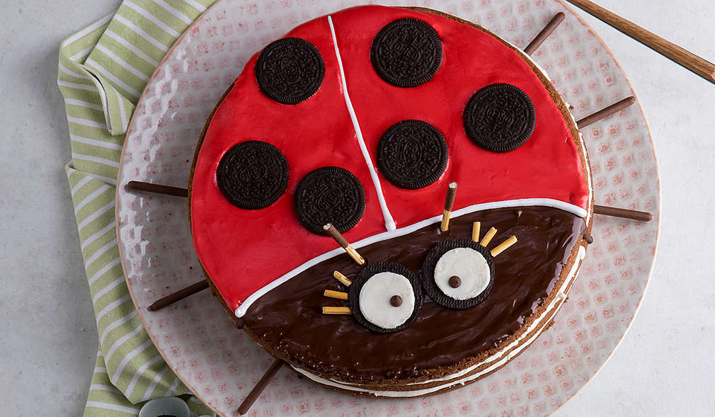 Kuchen mit roter Kuvertüre sowie Augen und Punkte aus Keksen