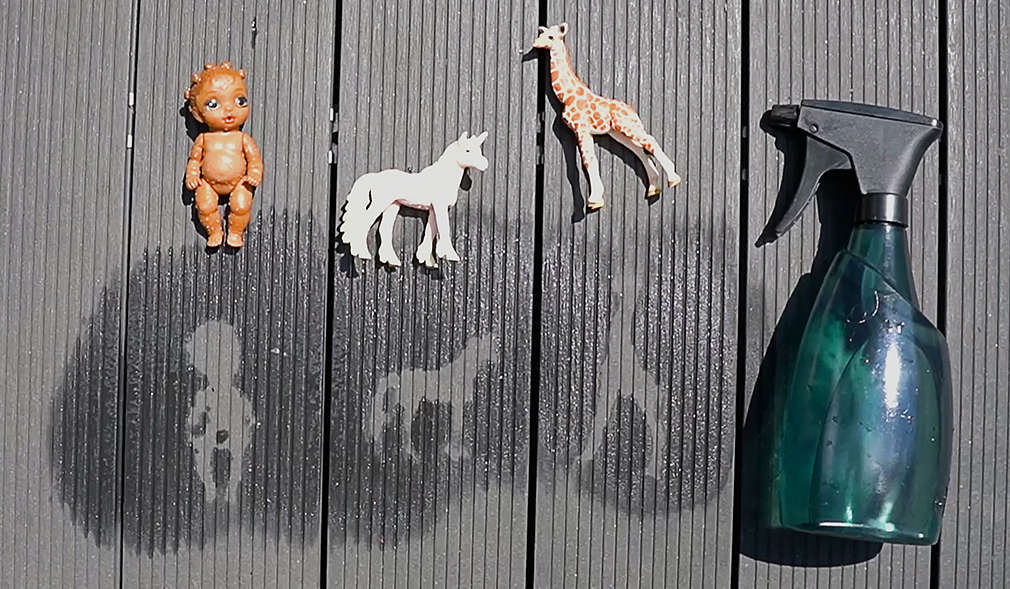 Spielzeug und dessen Silhouetten auf Holzboden