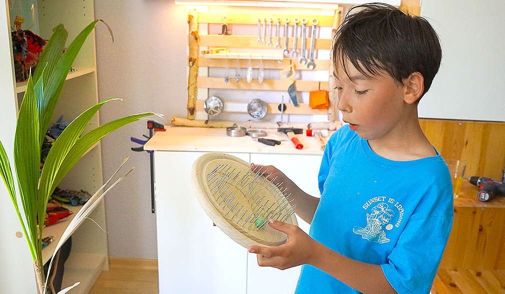 Junge hält ein selbst gemachtes Klanglabyrinth in der Hand