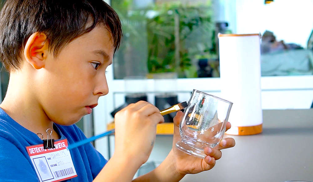 Junge mit Pinsel und Glas in der Hand