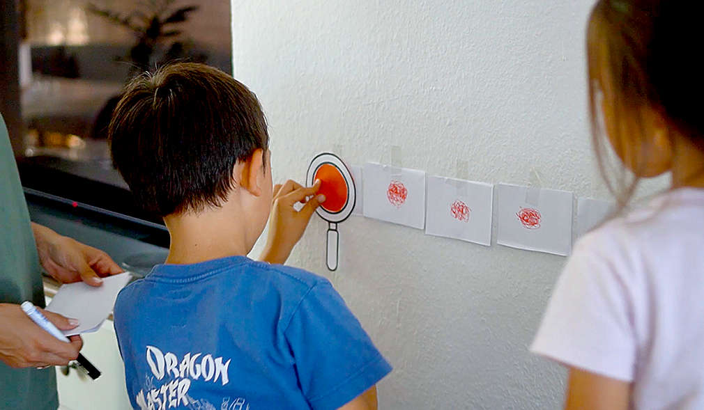 Kinder lesen Kritzelcodes mithilfe einer Lupe