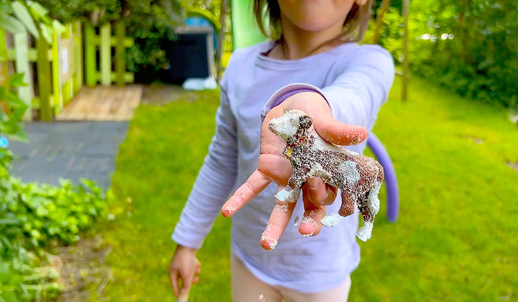 Kind hält Spielfigur in die Kamera