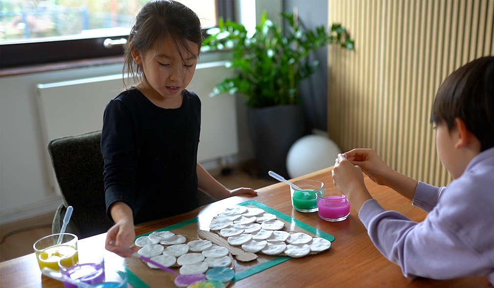 Mädchen und Junge färben Wattepads ein