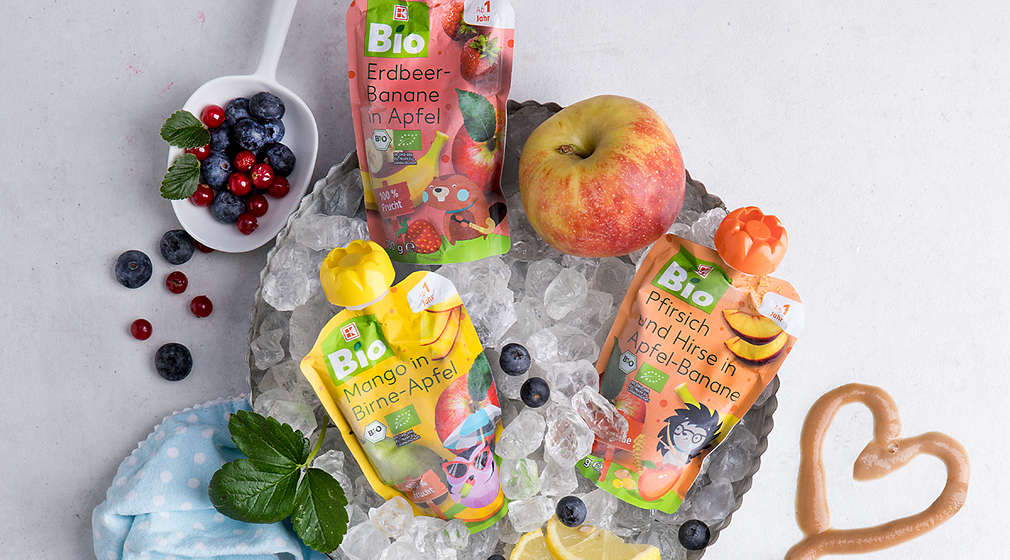 Mädchen isst einen Eis-Quetschie auf einer Schaukel