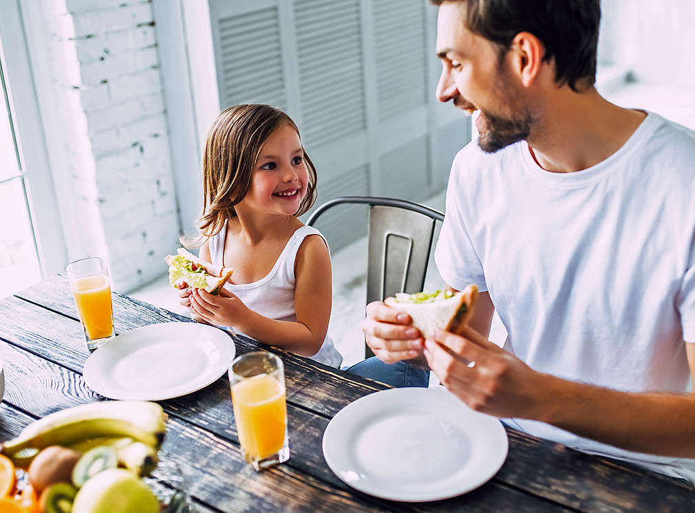 Vater und Tochter essen gemeinsam am Tisch