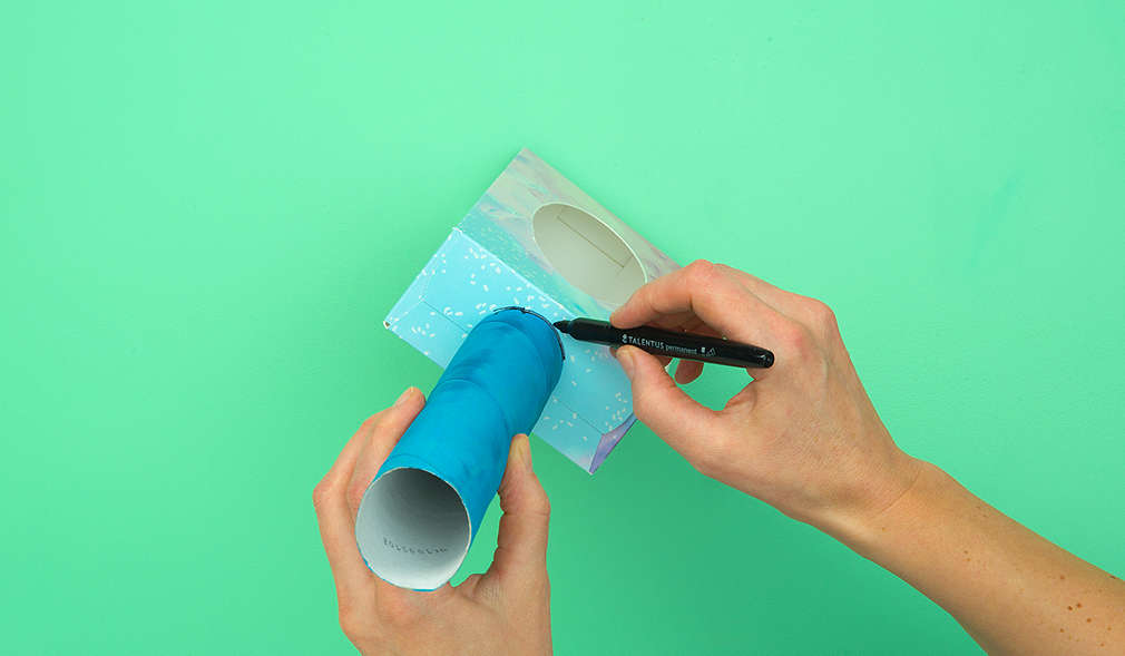 Aufzeichnen der Küchenrollengröße, um Loch in den Karton zu schneiden