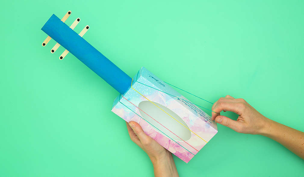 Gummibänder auf die gebastelte Gitarre spannen