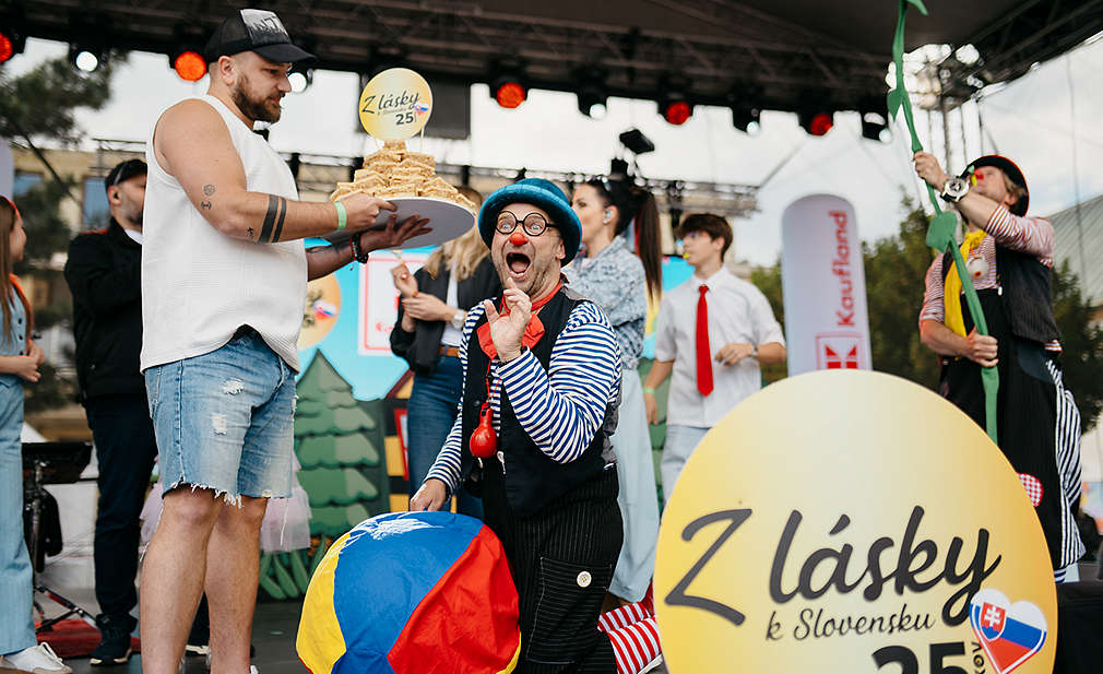 Rôzne osoby na pódiu oslavujú 25. výročia Kauflandu