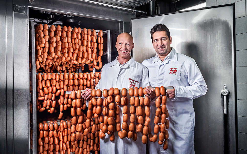 dva muži drží špekáčky Prantl