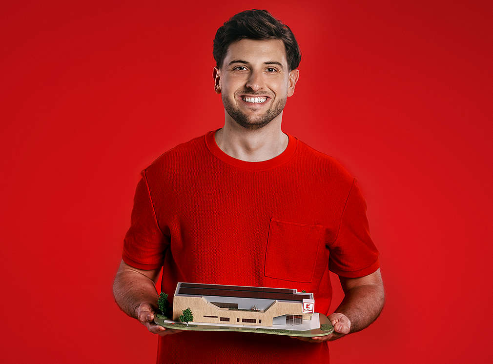 Zamestnanec Kauflandu drží v rukách maketu zeleného Kaufland budúcej generácie