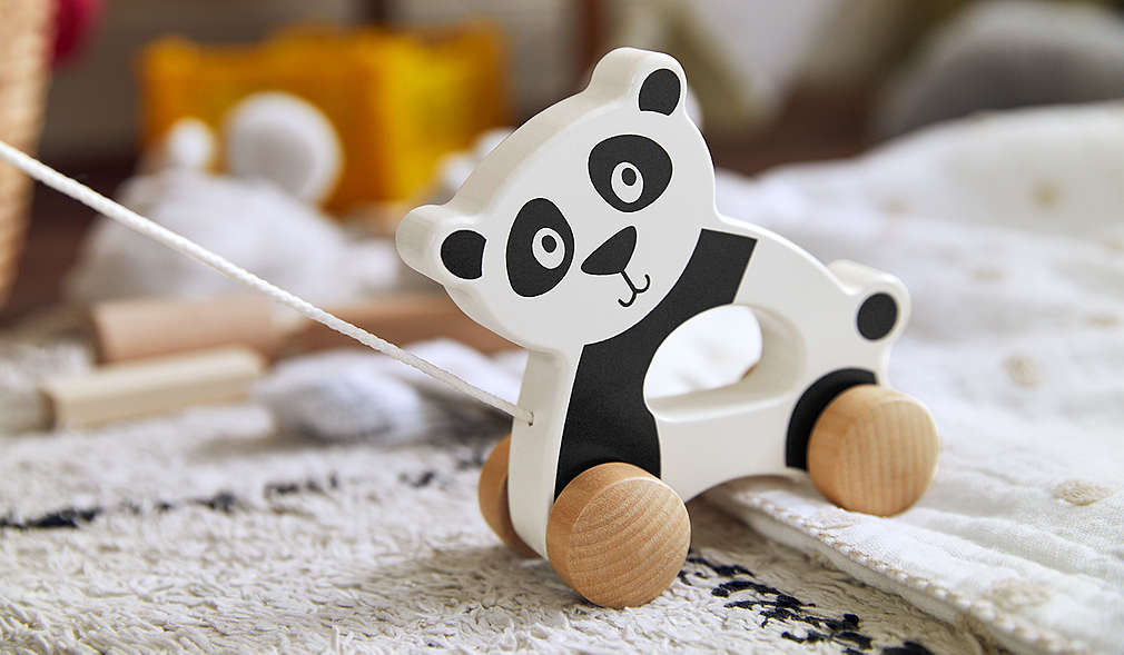 Kind auf Sofa mit verschiedenen Kuscheltieren