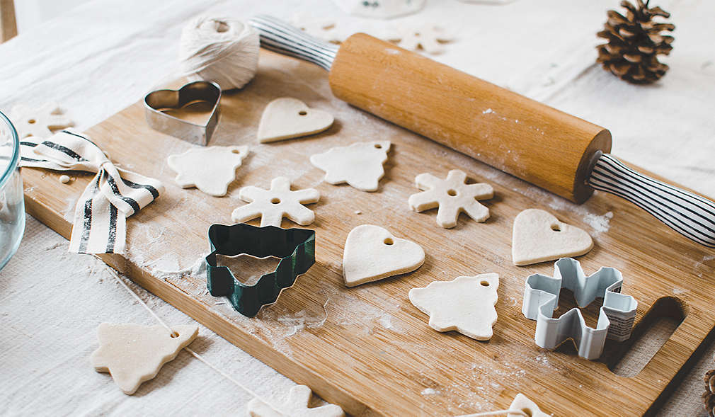 Selbst gemachter Christbaumschmuck aus Salzteig auf einem Holzbrett