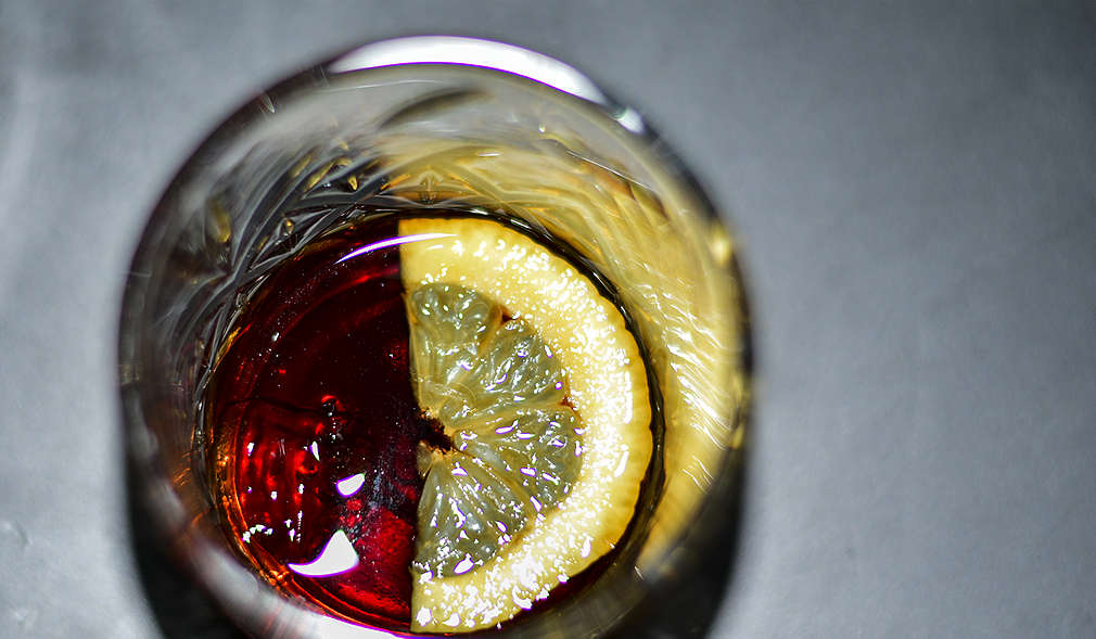 Italienischer Amaro in einem Glas mit Zitronenscheibe