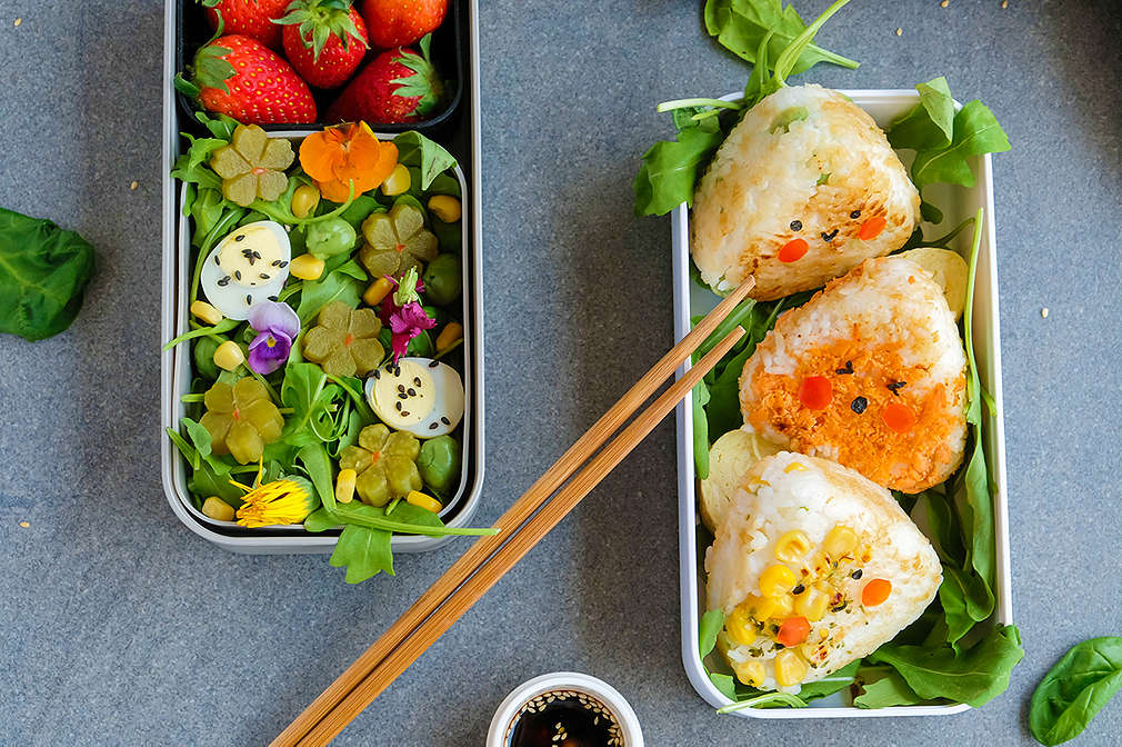 Onigiri in einer Brotdose mit Salat als Beilage