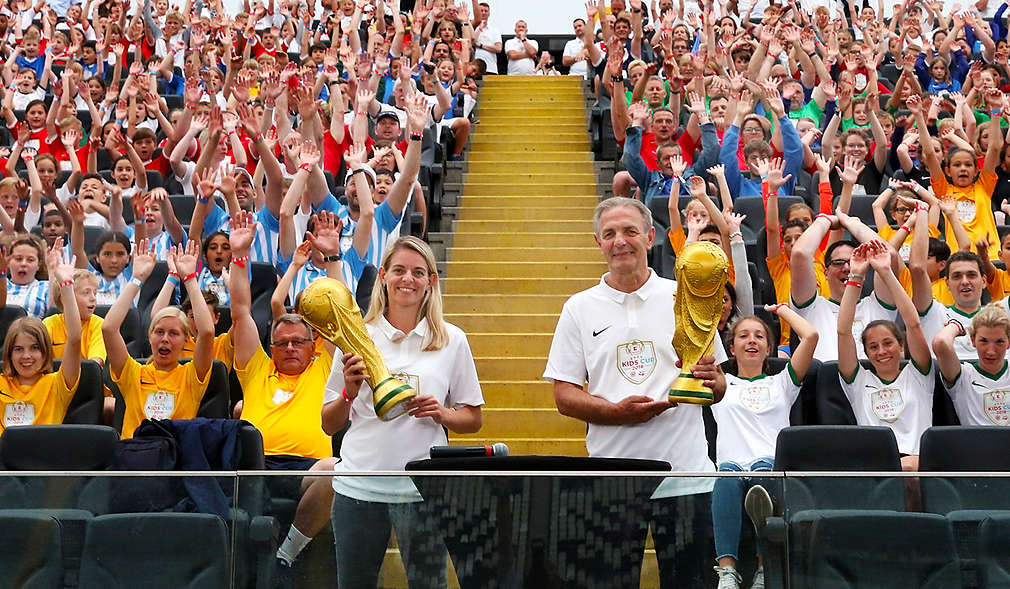 Charly Körbel hält Pokal im Stadion