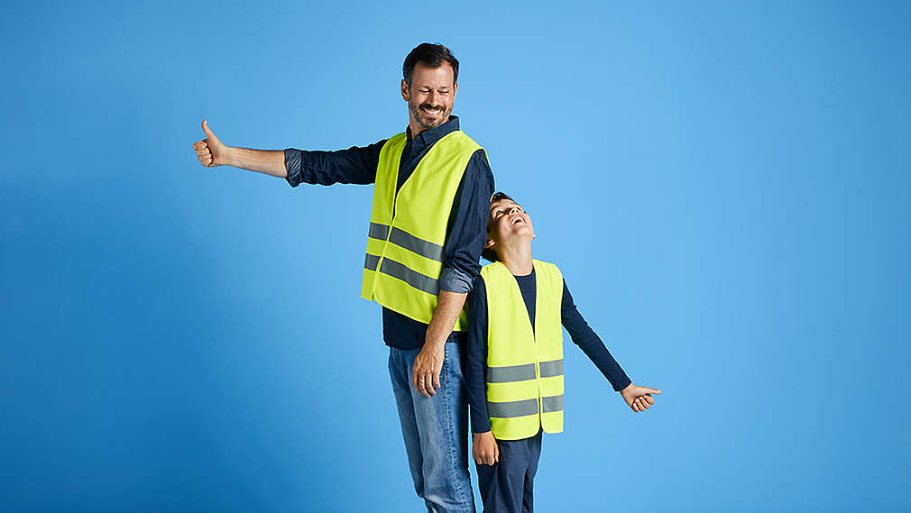 Ein Mann und ein Kind in Warnweste