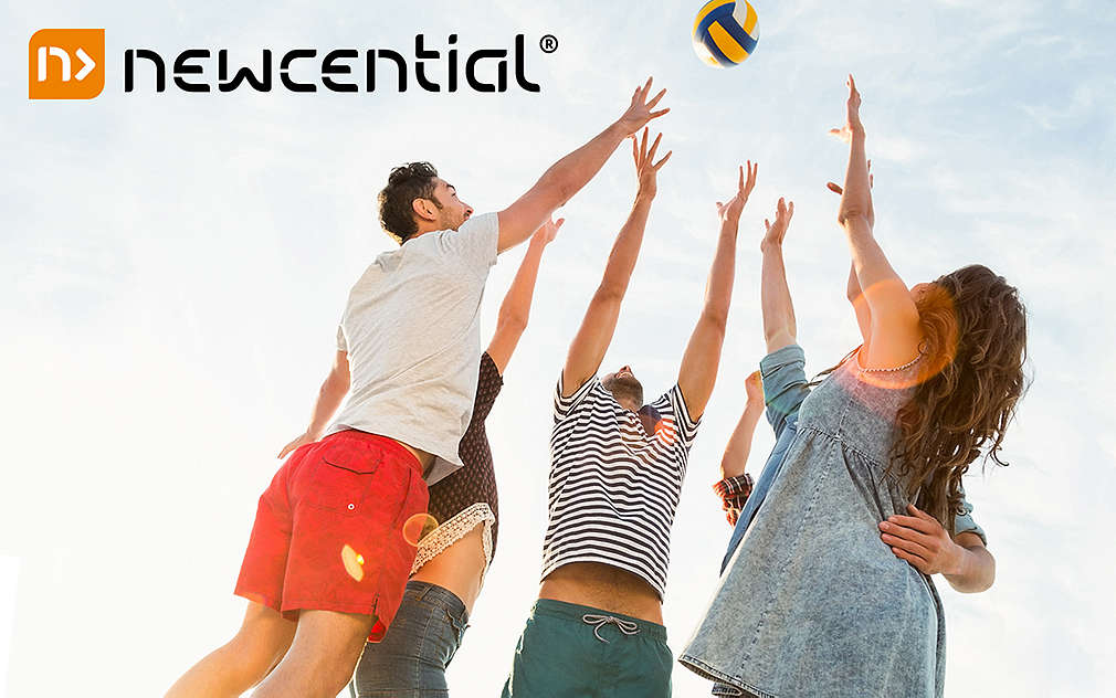 Team spielt Volleyball, alle springen zum Ball