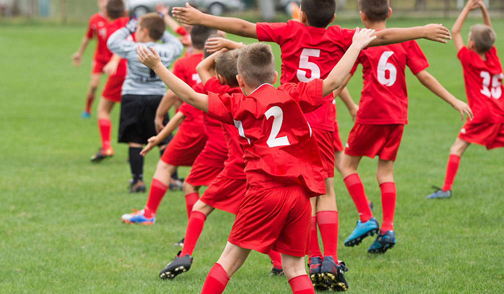 Kinder im Fußballtrikot auf Spielfeld