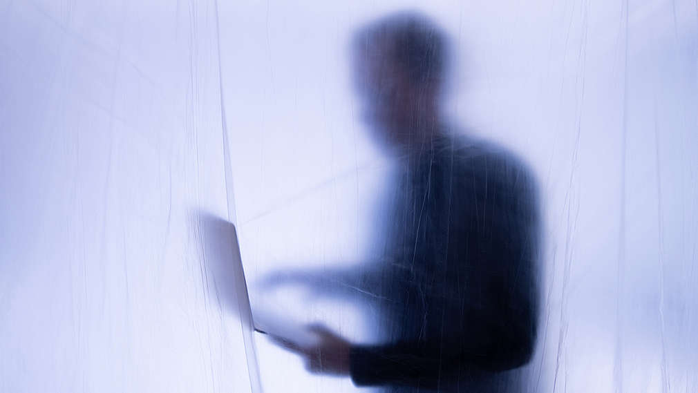 osoba v pozadí s notebookem