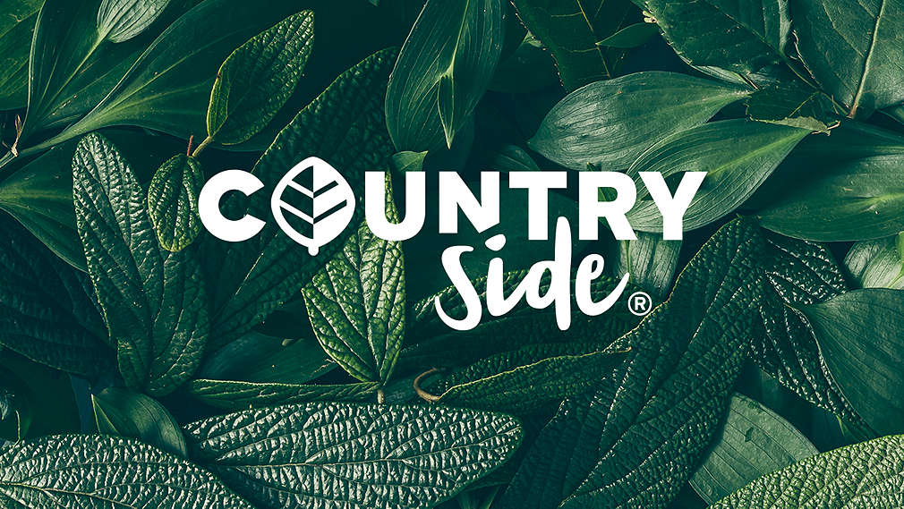 Логото на Countryside® върху много зелени листа