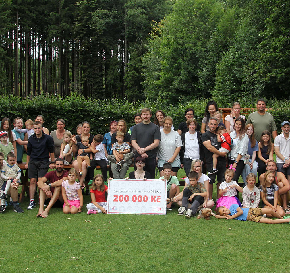 Zástupci Kaufland předávají poukaz na 200 000 Kč organizaci Debra ČR