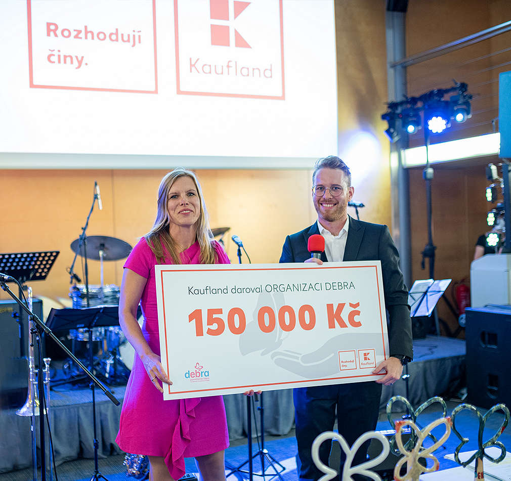 Zástupci Kaufland předávají poukaz na 150 000 Kš organizaci Debra ČR