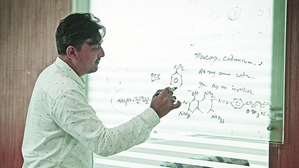 Profesor zapisuje wzór na tablicy.